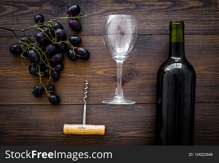 Composition With Wine. Red Wine Bottle, Bunch Of Grapes, Corkscrew, Wine Glass On Dark Wooden Background Top View