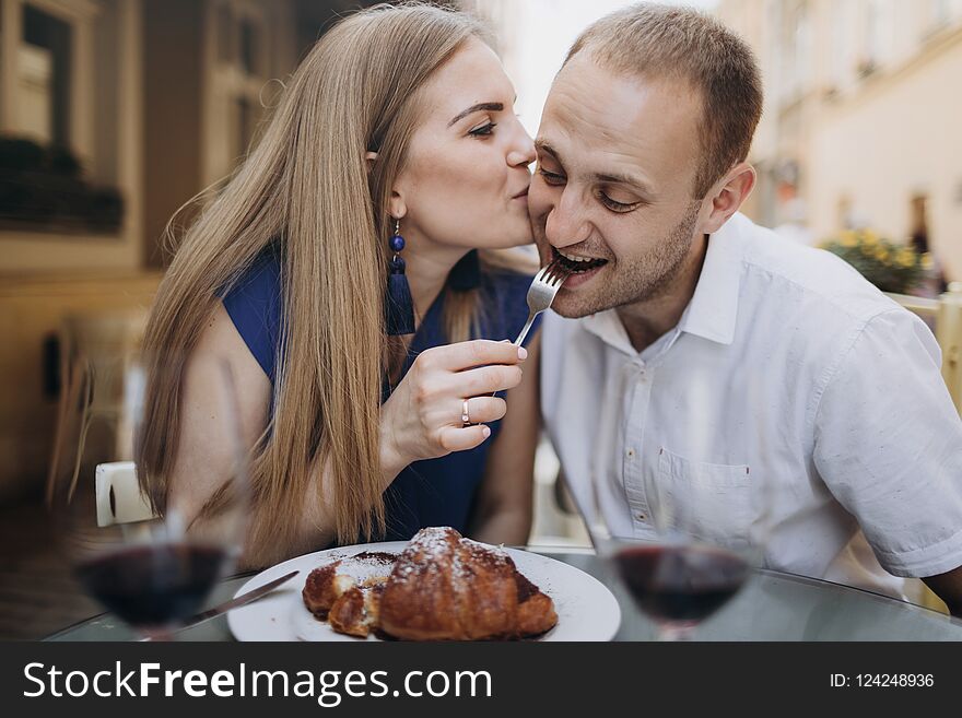 Cheerful couple in a restaurant with glasses of red wine. Young couple with glasses of red wine in a restaurant .
