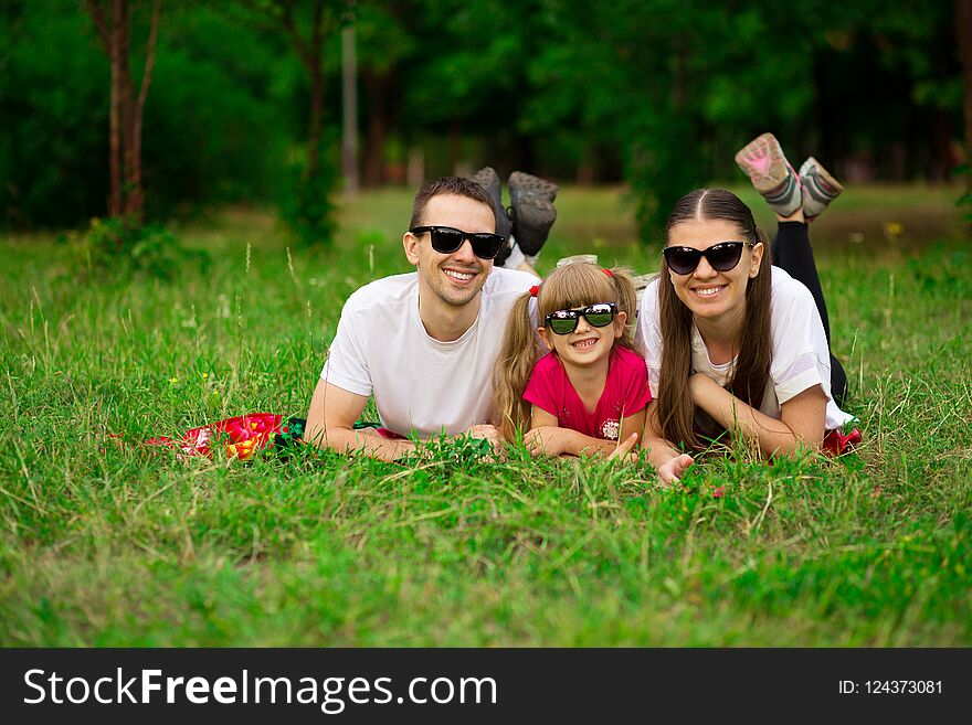 Happy young family spending time outdoor on summer day. Happiness and harmony in family life