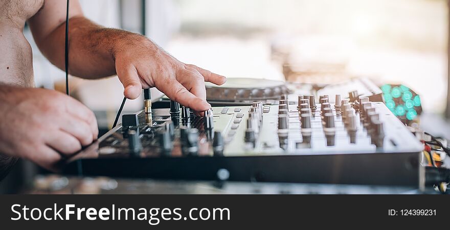 Close up of Disc Jockey hands plays music with DJ CD player and mixer on a private summer day party. Close up of Disc Jockey hands plays music with DJ CD player and mixer on a private summer day party