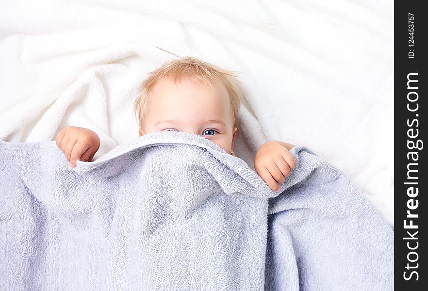Baby child in bed covering with blanket.Nursery for kids.