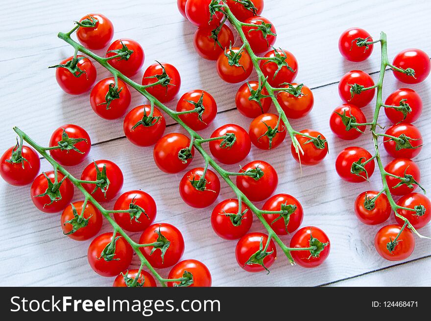 Four branches of ripe raw tomatoes at light grey textured background. Four branches of ripe raw tomatoes at light grey textured background
