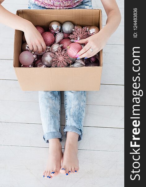 Happy christmas traditions of home and fir tree decoration, woman choosing the best adornments from a box with new year balls and toys mix. Happy christmas traditions of home and fir tree decoration, woman choosing the best adornments from a box with new year balls and toys mix.