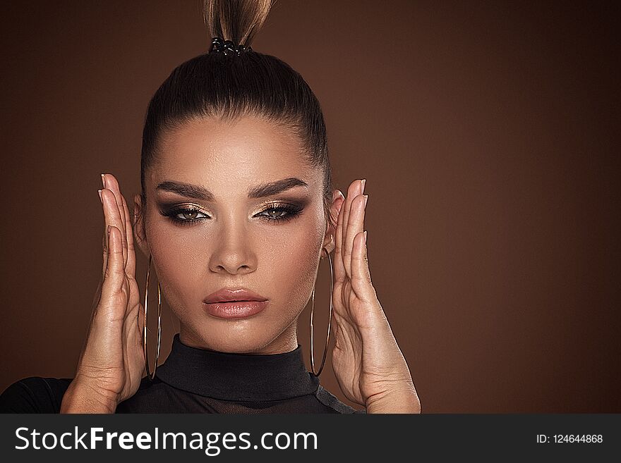 Face of attractive woman in golden makeup.