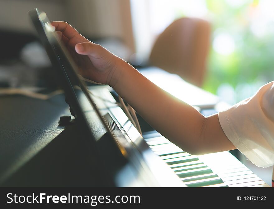 Little Boy Playing With Piano And Music Tablet At Home