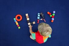 Little Blond Boy With Inscription PLAY Made From Different Toys Stock Photography