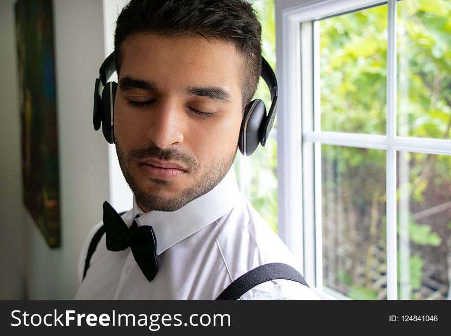 CEO, businessman wearing tuxedo listens to headphones with closed eyes