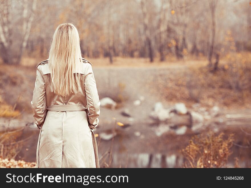 Stylish blond woman walking in the autumn park. Stylish blond woman walking in the autumn park