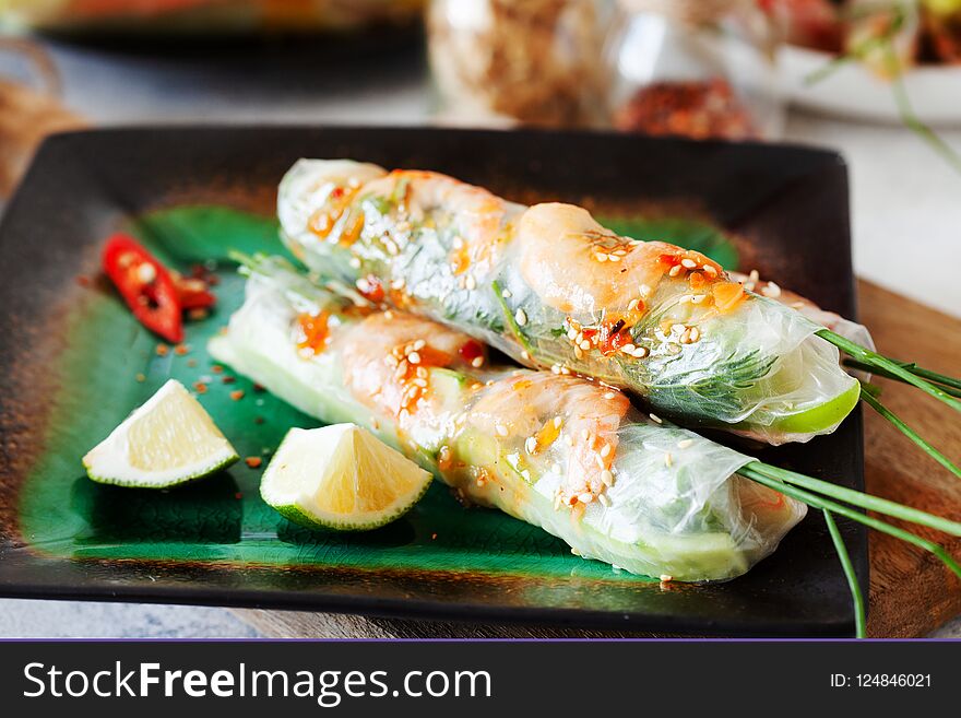 Fresh spicy vietnamese salad rolls with shrimp on a white plate close up