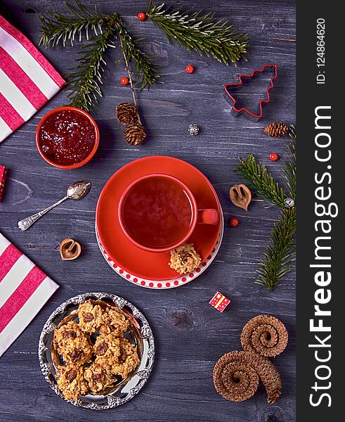 Raspberry tea, raspberry jam and homemade cookies on a dark wooden background. Top view