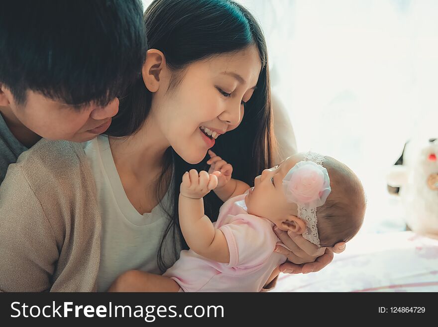 Closeup portrait of happy family with little baby on the bedroom.