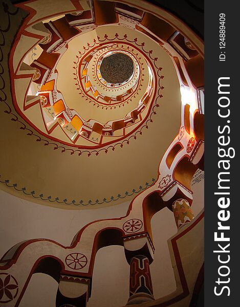 Looking up staircase with different symbols on handrail