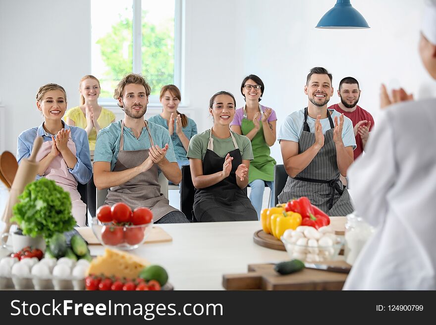 Group of people and female chef at cooking classes