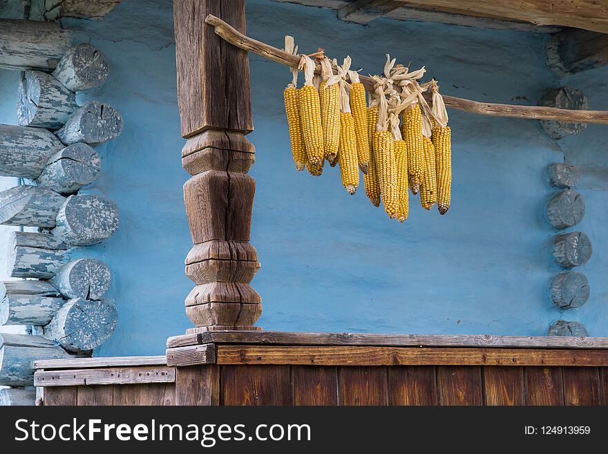 Wooden terrace in a rural national house with crocheted dried corn on the beam. Wooden terrace in a rural national house with crocheted dried corn on the beam