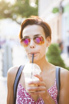 A Girl Drinks A Drink Through A Straw. Royalty Free Stock Photo