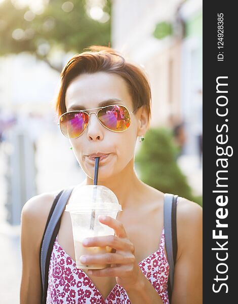 A girl drinks a drink through a straw.