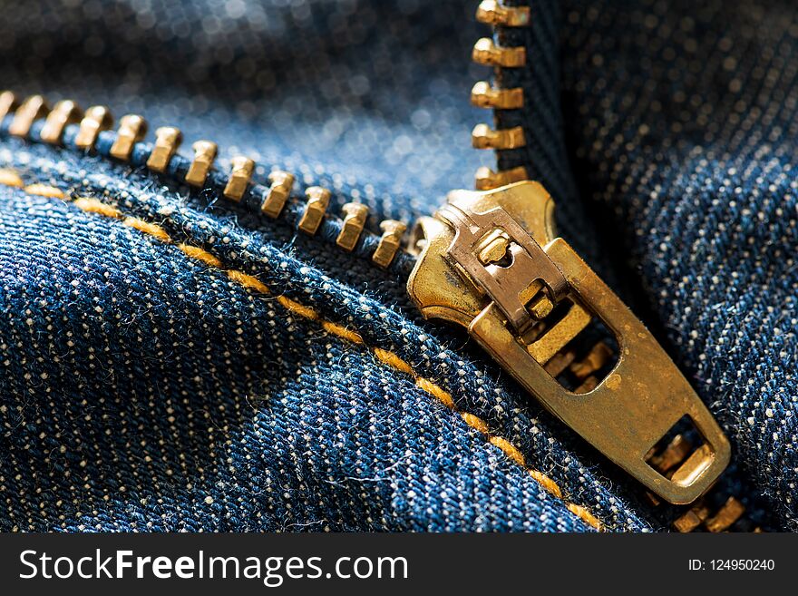 Close up and macro blue jeans zipper on blue jeans background. Close up and macro blue jeans zipper on blue jeans background.