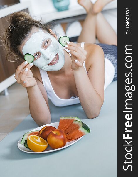 Young Pretty Blonde woman with towel on head and facial mask wit
