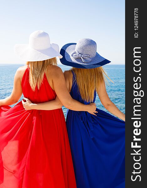 Blond women in the red and blue dresses at the beach in Cyprus.