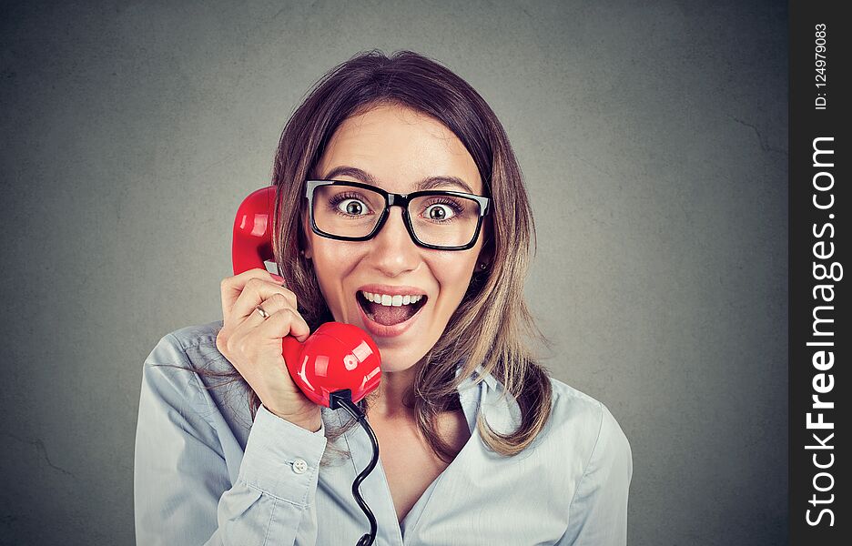 Portrait Of A Happy Amazed Woman Talking On The Red Phone