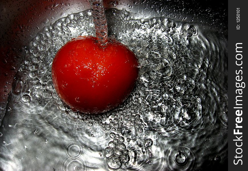 Tomato in water, close up. Tomato in water, close up