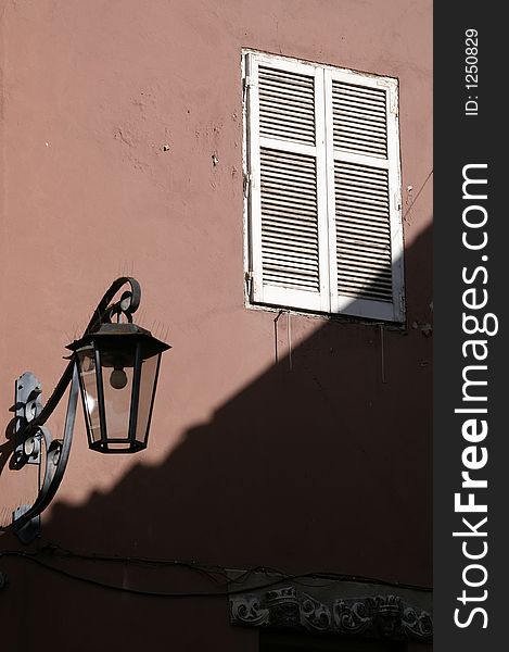 Lamp  and closed window by faÃ§ade in Meran, Italy (South Tyrol), Alps. Lamp  and closed window by faÃ§ade in Meran, Italy (South Tyrol), Alps