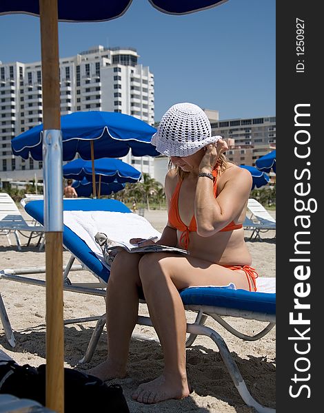Florida woman reading book under umbrella