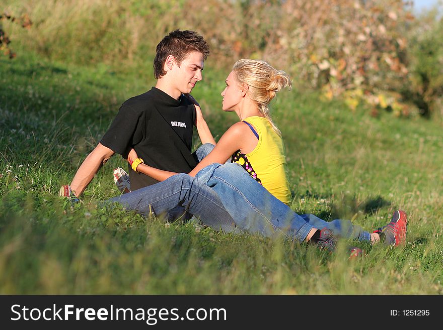 Young couple enjoying each other on the grass in the park. Young couple enjoying each other on the grass in the park
