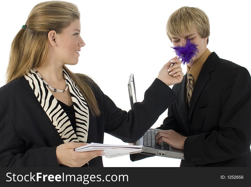 Teen girl tickles teen boy with feather pen. Dressed in business suits. Teen girl tickles teen boy with feather pen. Dressed in business suits.