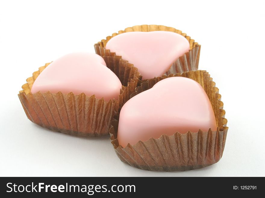 Pink love heart chocolates on a white background