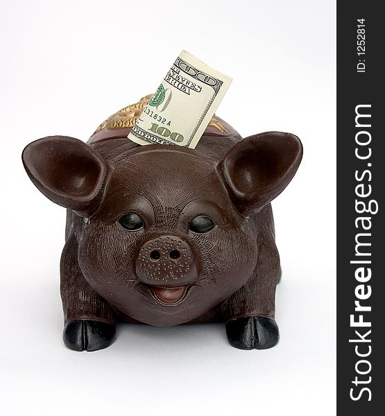 Piggy bank with U.S. one hundred dollars in slot.Isolated on white.