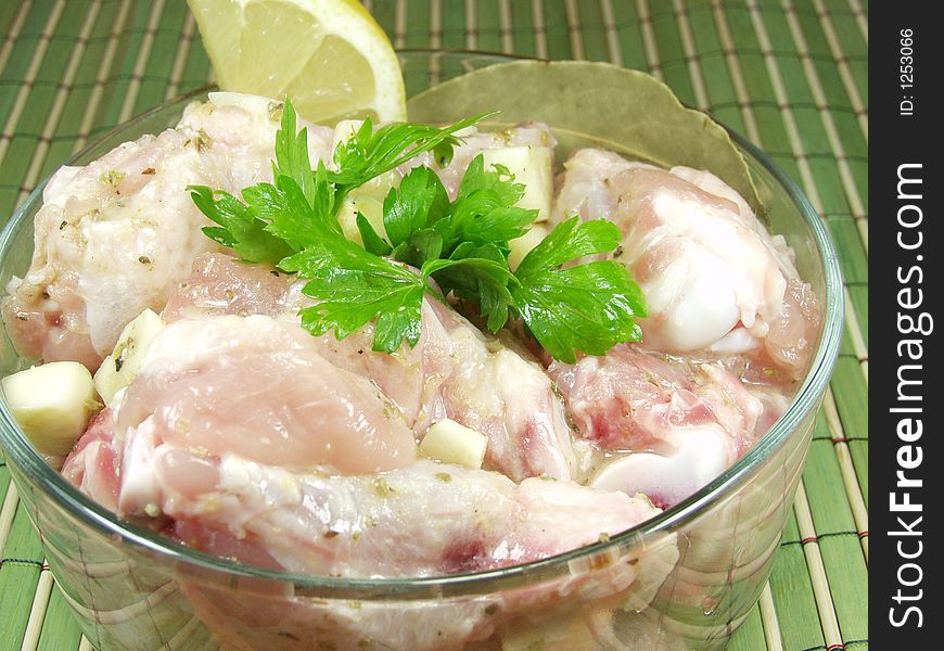 Raw uncooked wings chicken with seasonings, lemon and parsley is ready to the further culinary processing