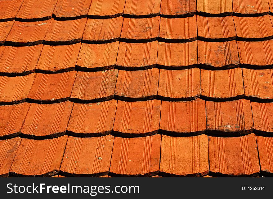 Orange/red roof of old country house as background. Orange/red roof of old country house as background