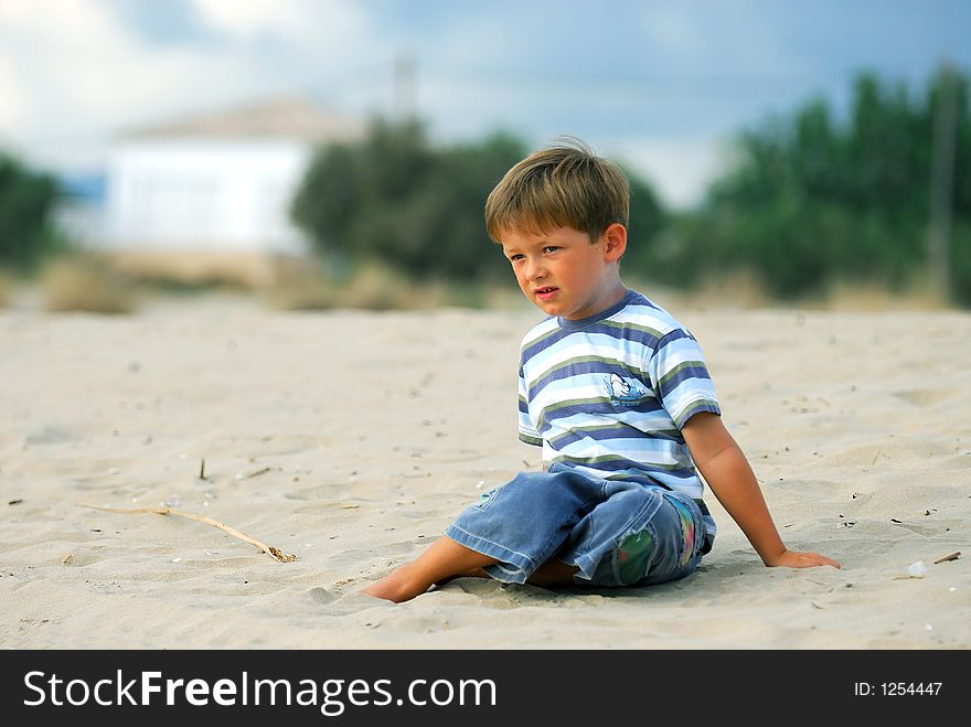 Young boy is daydreaming at the beach. Young boy is daydreaming at the beach