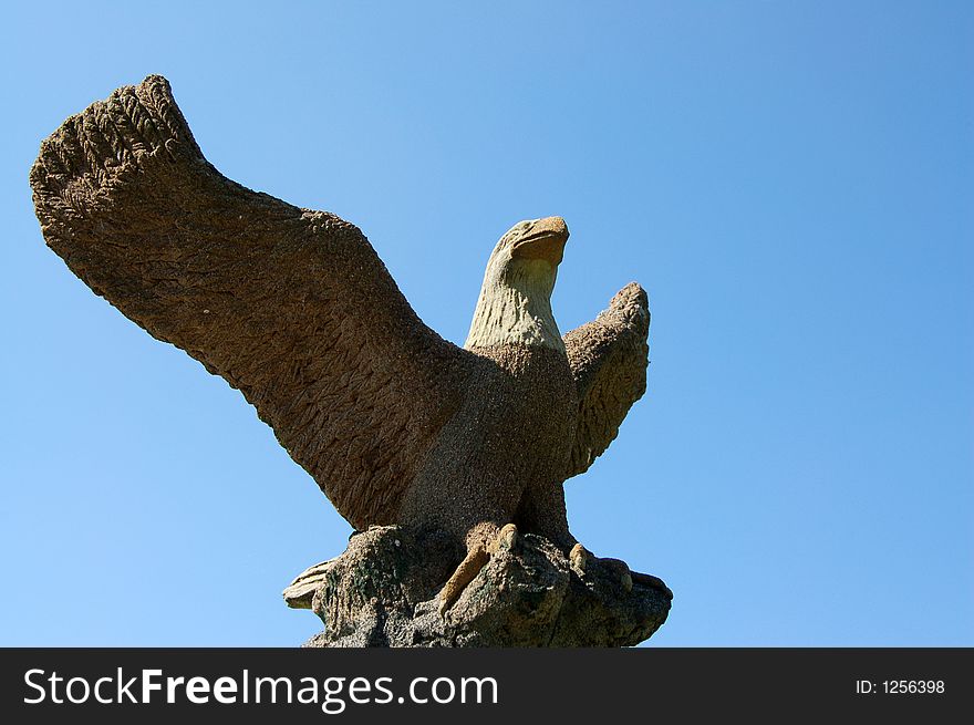 A statue of an eagle with blue sky.