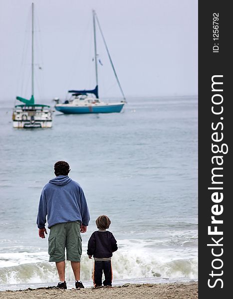 A father and his son looking at sailboats. A father and his son looking at sailboats.