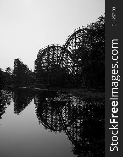 Wooden rollercoaster with a lake reflection - vertical composition. Wooden rollercoaster with a lake reflection - vertical composition