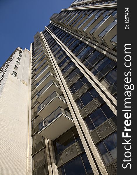 Tall luxury apartment building with balconies.