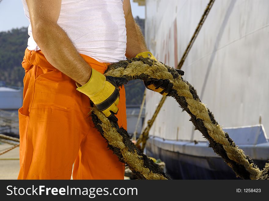 Worker in bar's port working with string. Worker in bar's port working with string