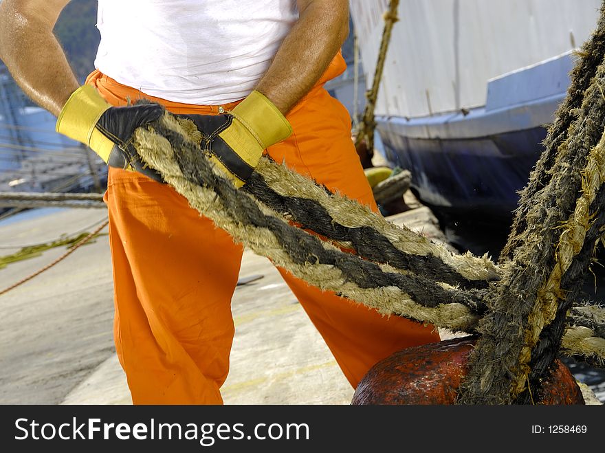 Worker in bar's port working with string. Worker in bar's port working with string