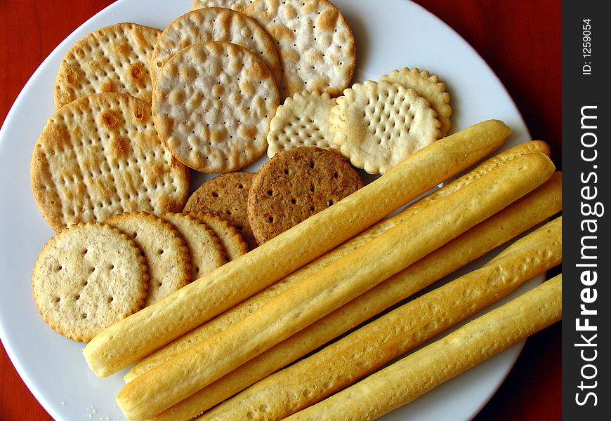 Assorted biscuits in with plate set on a wooden table.