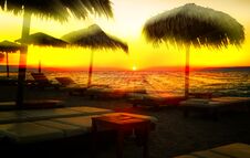Sun Rays Cut Through Beach Umbrellas At Sunset Sandy Beach, Europe, Greece, Crete Royalty Free Stock Image