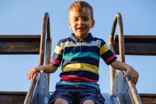 Summer, Childhood, Friendship And People Concept - Happy Little Boy On Children Playground Slid From The Hill Royalty Free Stock Photos