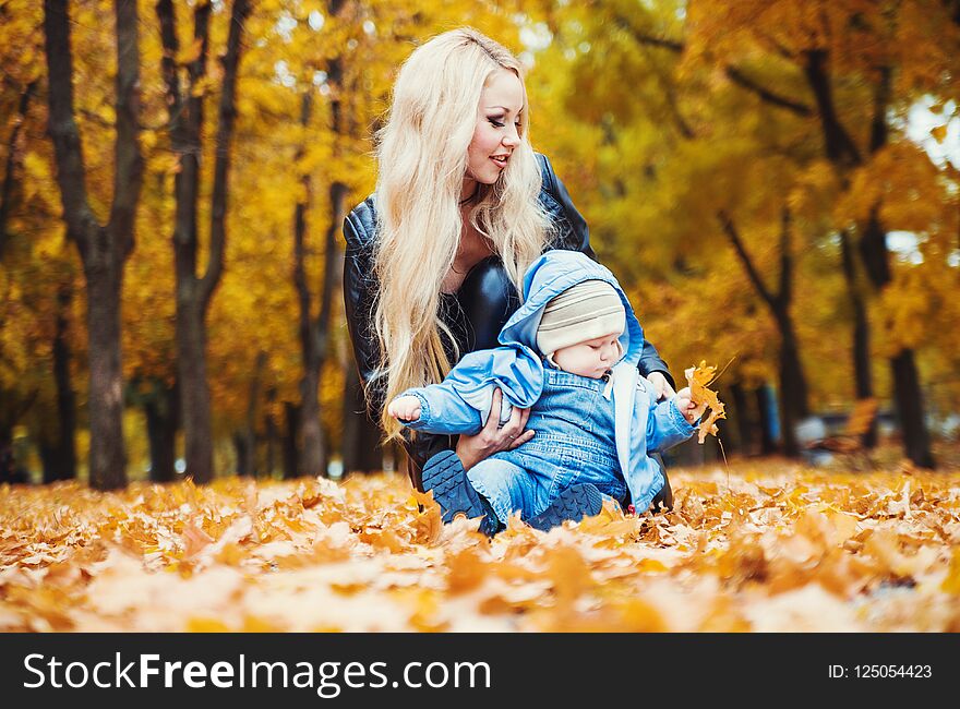 Cute little boy with his mother in autumn park.