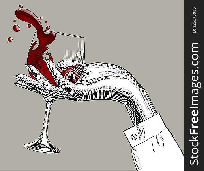 Woman`s Hand Holding A Glass With Red Splashed Wine