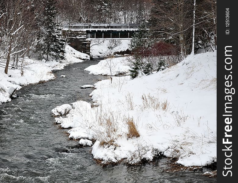 Scenic view of river in Wintry wood with bridge in background. Scenic view of river in Wintry wood with bridge in background.