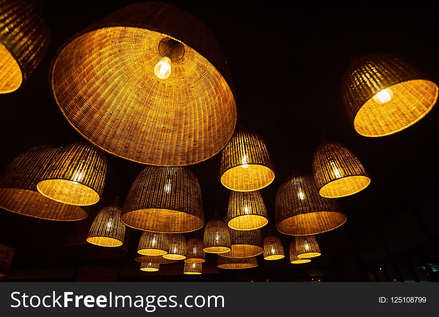 Local shaped lamps on ceiling against dark background, many local ceiling lamps with abstract ornament as chandelier, decoration, design, interior, wooden, art, beautiful, bright, brown, decorative, electricity, hanging, illuminated, light, material, restaurant, retro, style, vintage, wicker, handmade, basket, blur, building, concept, craft, fashion, food, glitter, glow, handicraft, market, object, old, outdoor, straw, summer, texture, thai, thailand, traditional, transparent, weave, white, woven