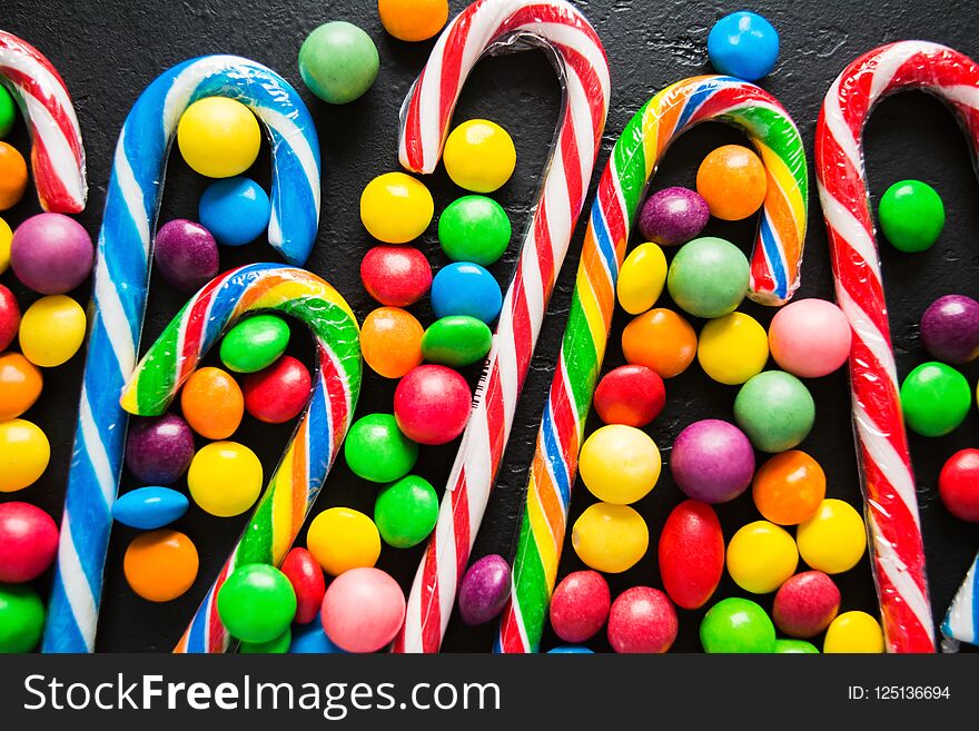 Colorful candies on black, flat lay