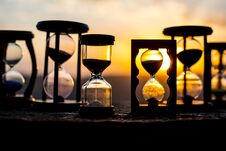 Hourglass Passing Of Time Lapse Clouds. An Hourglass In Front Of A Bright Blue Sky With Puffy White Clouds Passing. Time Concept. Royalty Free Stock Photo Hourglass Passing Of Time Lapse Clouds. An Hourglass In Front Of A Bright Blue Sky With Puffy White Clouds Passing. Time Concept. Royalty Free Stock Photo