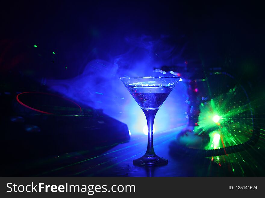 Glass with martini with olive inside on dj controller in night club. Dj Console with club drink at music party in nightclub with d